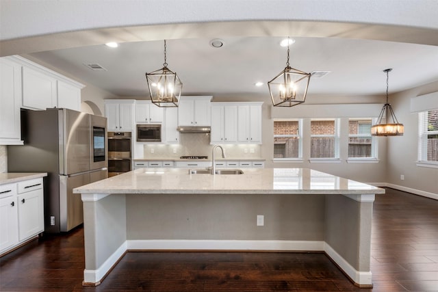 15002 House Martin Ln, Cypress, TX 77429 - kitchen featuring a sink, a chandelier, appliances with stainless steel finishes, under cabinet range hood, and decorative backsplash
