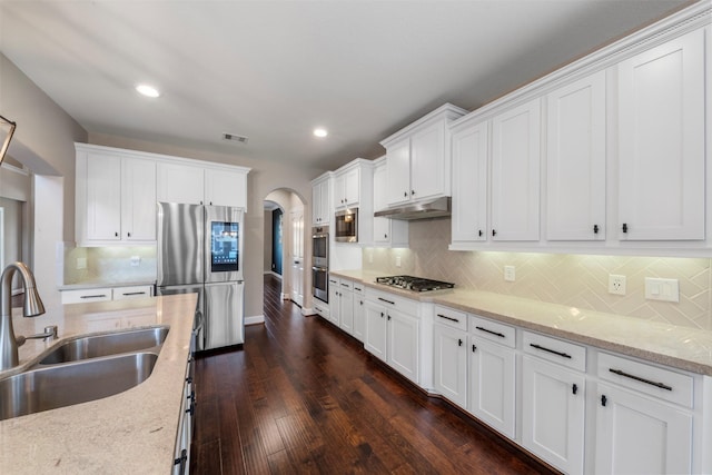 15002 House Martin Ln, Cypress, TX 77429 - kitchen featuring a sink, stainless steel appliances, arched walkways, under cabinet range hood, and white cabinetry