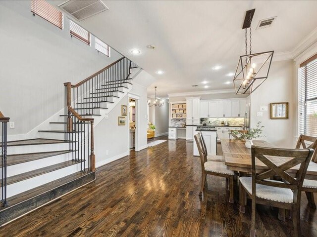 1200 W 24th St, Houston, TX 77008 - dining space featuring a chandelier, crown molding, stairway, dark wood-style flooring, and recessed lighting