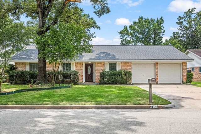 2113 Timber Ln, Conroe, TX 77301 - ranch-style home with driveway, a garage, a front yard, and brick siding