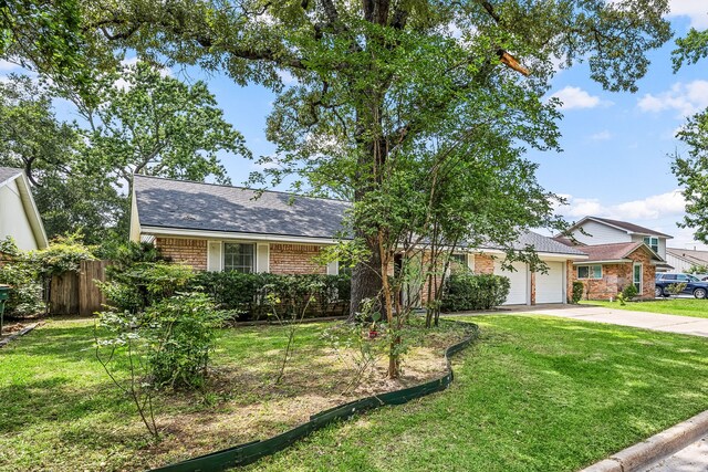 2113 Timber Ln, Conroe, TX 77301 - view of front of property featuring concrete driveway, an attached garage, brick siding, and roof with shingles