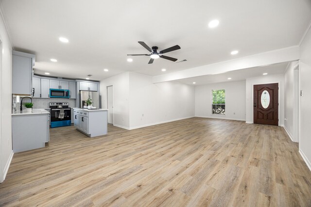 2113 Timber Ln, Conroe, TX 77301 - unfurnished living room featuring ceiling fan, recessed lighting, light wood-style floors, baseboards, and ornamental molding