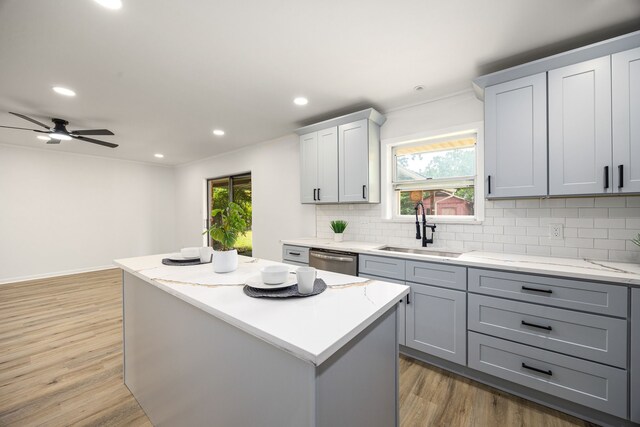 2113 Timber Ln, Conroe, TX 77301 - kitchen with a sink, gray cabinetry, stainless steel dishwasher, decorative backsplash, and light wood-style floors