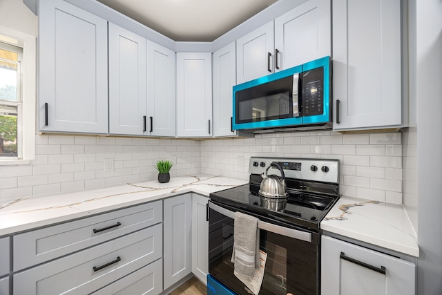2113 Timber Ln, Conroe, TX 77301 - kitchen featuring stainless steel appliances, light stone countertops, and tasteful backsplash
