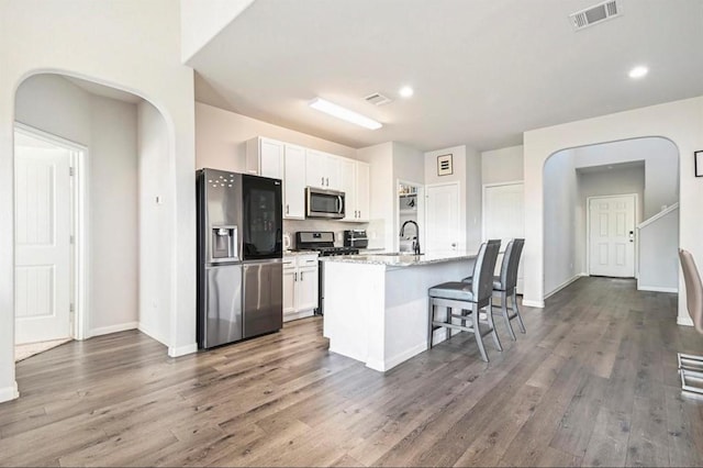 23523 Montague Dr, Spring, TX 77373 - kitchen with stainless steel appliances, a sink, dark wood finished floors, a center island with sink, and recessed lighting