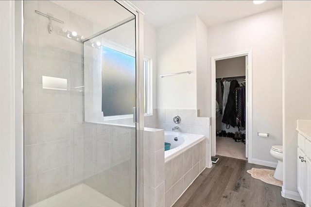 23523 Montague Dr, Spring, TX 77373 - bathroom featuring vanity, a shower stall, a bath, wood finished floors, and a walk in closet