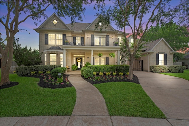 3707 Doyle Ct, Missouri City, TX 77459 - view of front facade featuring a balcony, a gate, brick siding, and a front lawn