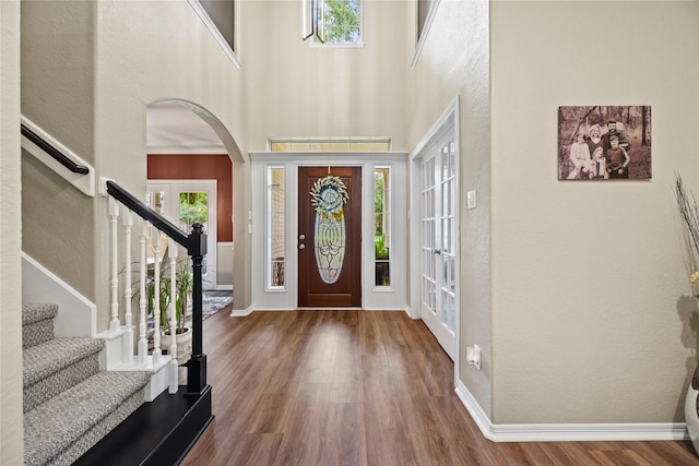 3707 Doyle Ct, Missouri City, TX 77459 - entrance foyer featuring wood finished floors, arched walkways, stairway, a towering ceiling, and baseboards