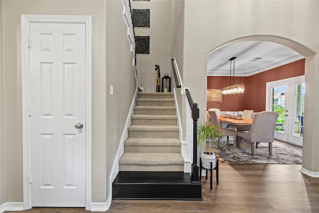 3707 Doyle Ct, Missouri City, TX 77459 - stairs featuring arched walkways, wood finished floors, crown molding, a chandelier, and baseboards