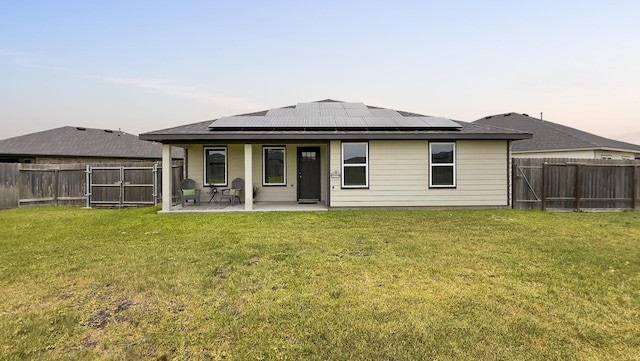 29419 Georgia Throw Ln, Katy, TX 77494 - back of property at dusk with a gate, roof mounted solar panels, and a patio