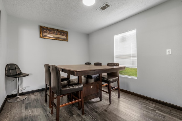 541 Trails End Dr, Cleveland, TX 77328 - dining area featuring dark wood-style flooring, a textured ceiling, and baseboards