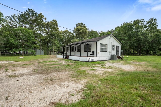 541 Trails End Dr, Cleveland, TX 77328 - view of front of home with entry steps, central air condition unit, a front yard, and view of wooded area