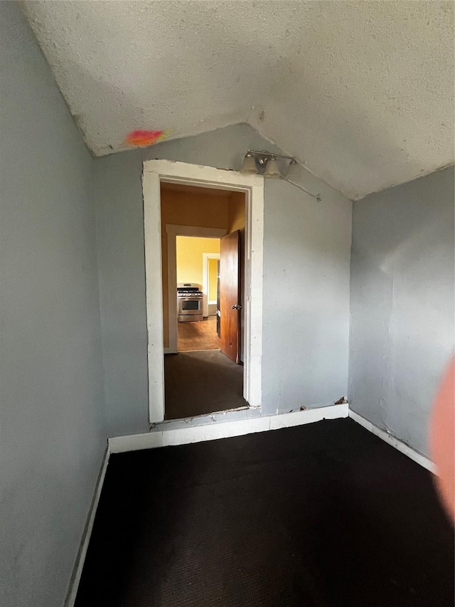 6015 Brady St, Houston, TX 77011 - spare room featuring vaulted ceiling, a textured ceiling, and baseboards