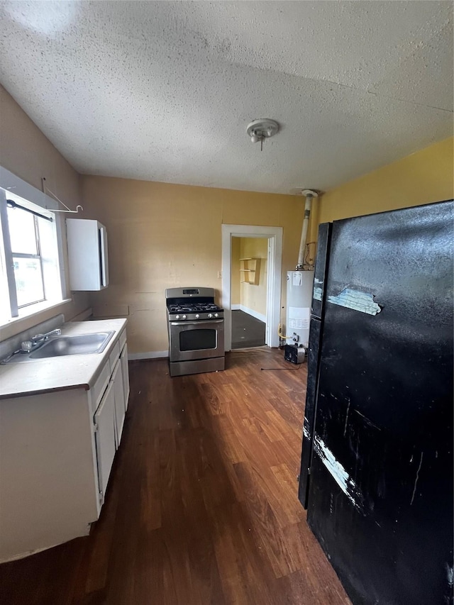 6015 Brady St, Houston, TX 77011 - kitchen featuring stainless steel gas range oven, a sink, dark wood-style flooring, a textured ceiling, and light countertops
