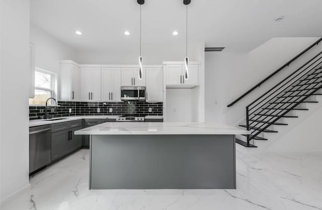 6732 Goforth, Houston, TX 77021 - kitchen featuring stainless steel appliances, a sink, light stone countertops, decorative backsplash, and a kitchen island