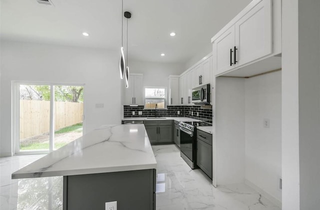 6732 Goforth, Houston, TX 77021 - kitchen featuring stainless steel appliances, a sink, a kitchen island, backsplash, and light marble finish floors