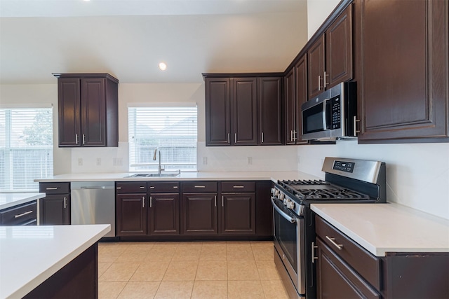 2630 Sable Ridge Ln, Katy, TX 77494 - kitchen with stainless steel appliances, a sink, light countertops, dark brown cabinetry, and recessed lighting
