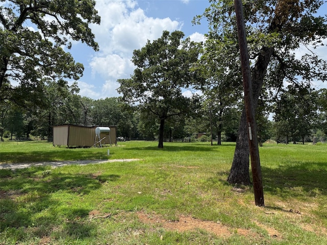 7719 County Road 233, Centerville, TX 75833 - view of green lawn with an outdoor structure and an outbuilding