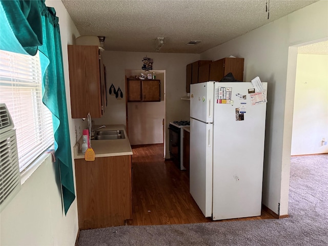 7719 County Road 233, Centerville, TX 75833 - kitchen featuring freestanding refrigerator, gas range, a sink, light countertops, and a textured ceiling