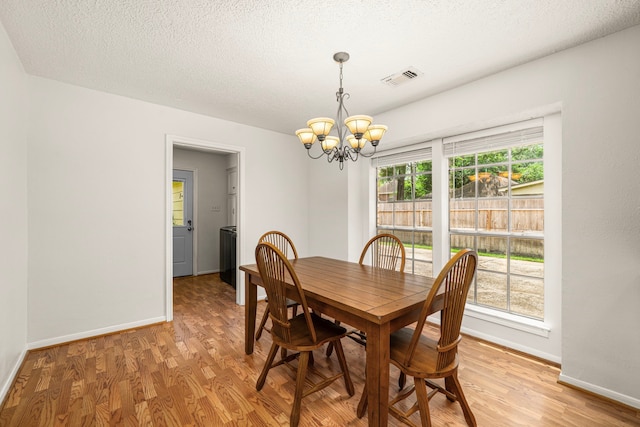 8023 Litchfield Ln, Spring, TX 77379 - dining room with a chandelier, light wood-type flooring, baseboards, and a textured ceiling