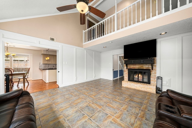 8023 Litchfield Ln, Spring, TX 77379 - living room featuring a decorative wall, ceiling fan, high vaulted ceiling, a fireplace, and ornamental molding