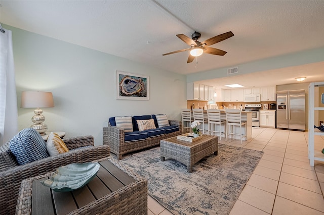 1717 22nd St, Galveston, TX 77550 - living area with a ceiling fan, light tile patterned floors, and a textured ceiling