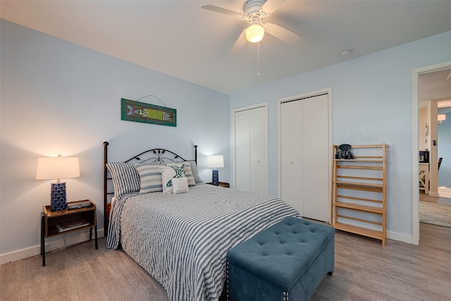 1717 22nd St, Galveston, TX 77550 - bedroom featuring two closets, wood finished floors, baseboards, and a ceiling fan