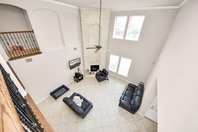 3922 Crestwind Ln, Richmond, TX 77407 - unfurnished living room featuring a large fireplace, plenty of natural light, a ceiling fan, a high ceiling, and crown molding