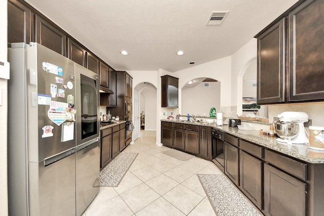3922 Crestwind Ln, Richmond, TX 77407 - kitchen with smart refrigerator, arched walkways, dishwasher, dark brown cabinetry, and light tile patterned floors