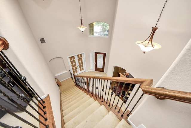 3922 Crestwind Ln, Richmond, TX 77407 - staircase featuring a high ceiling and french doors