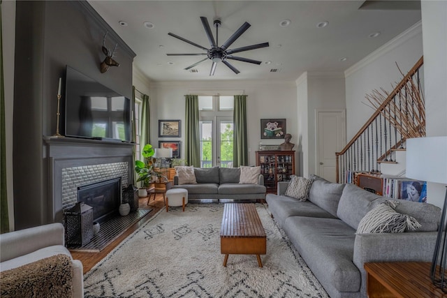 242 E 28th St, Houston, TX 77008 - living area featuring ceiling fan, wood finished floors, stairway, a tile fireplace, and crown molding