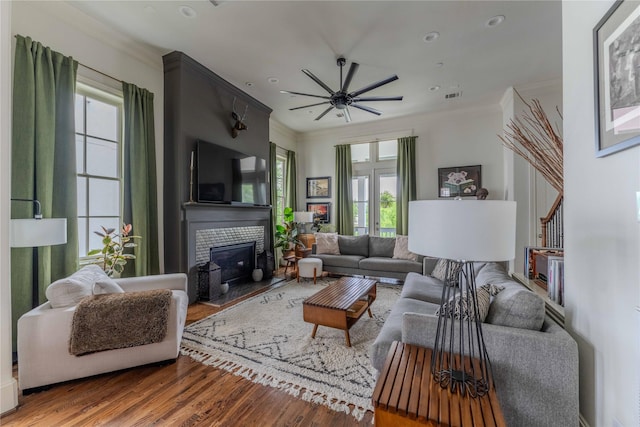 242 E 28th St, Houston, TX 77008 - living area with plenty of natural light, wood finished floors, a fireplace with raised hearth, a ceiling fan, and crown molding