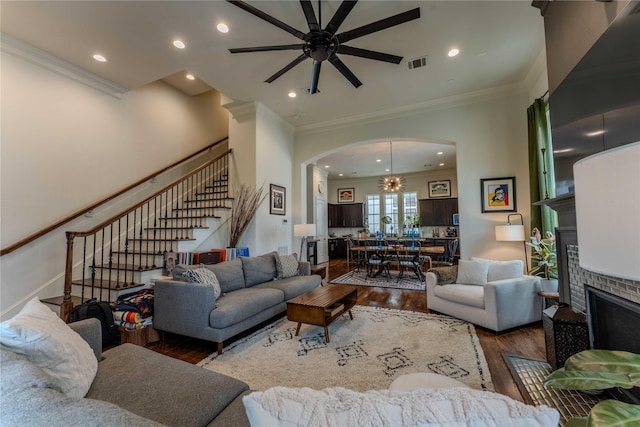 242 E 28th St, Houston, TX 77008 - living room with wood finished floors, stairway, a ceiling fan, arched walkways, and a brick fireplace