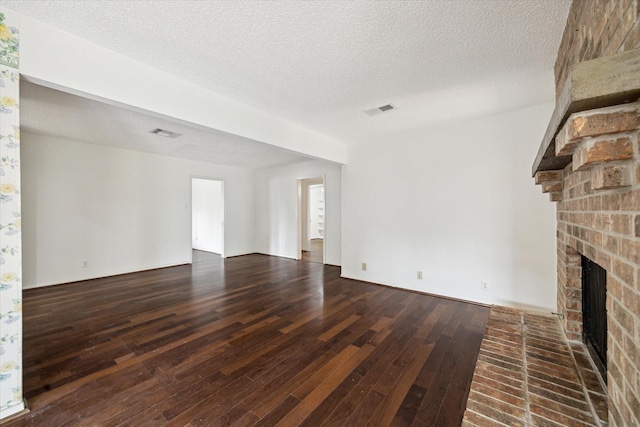 8721 Greiner Dr, Houston, TX 77080 - unfurnished living room featuring hardwood / wood-style floors, a fireplace, and a textured ceiling