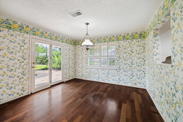 8721 Greiner Dr, Houston, TX 77080 - unfurnished dining area featuring wallpapered walls, dark wood finished floors, baseboards, and a textured ceiling