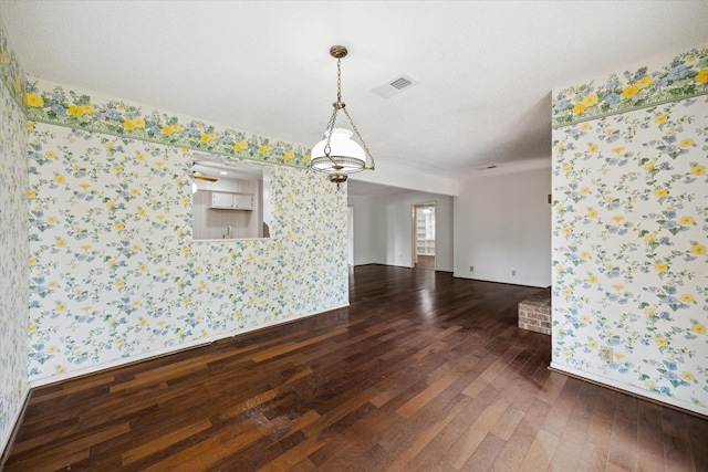 8721 Greiner Dr, Houston, TX 77080 - unfurnished room featuring wallpapered walls, dark wood finished floors, and baseboards