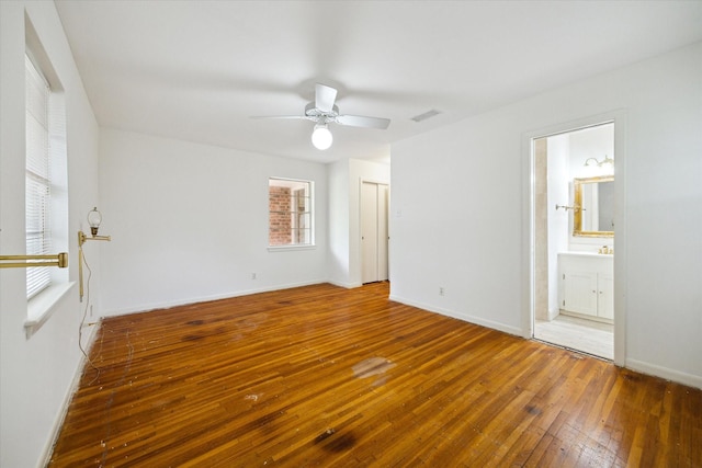 8721 Greiner Dr, Houston, TX 77080 - unfurnished bedroom featuring wood-type flooring, baseboards, ceiling fan, and connected bathroom