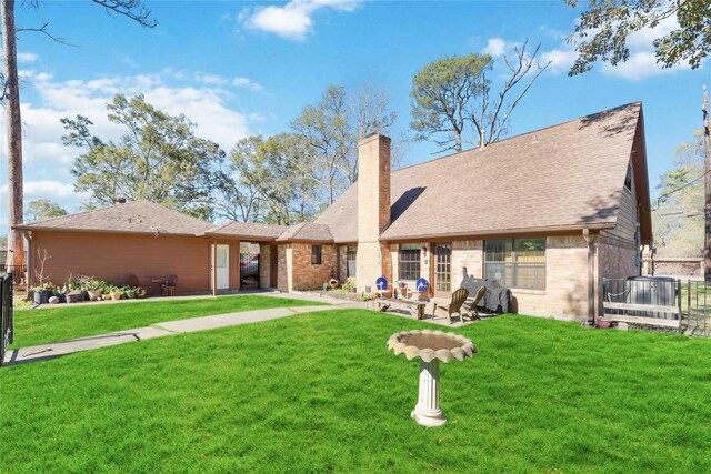 1823 White Feather Trl, Crosby, TX 77532 - rear view of house featuring brick siding, roof with shingles, and a lawn