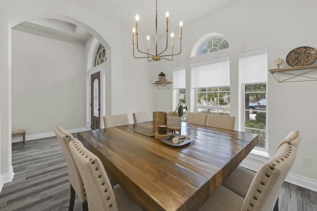 16819 Talisker Dr, Richmond, TX 77407 - dining room with dark wood-style flooring, baseboards, arched walkways, a chandelier, and a towering ceiling