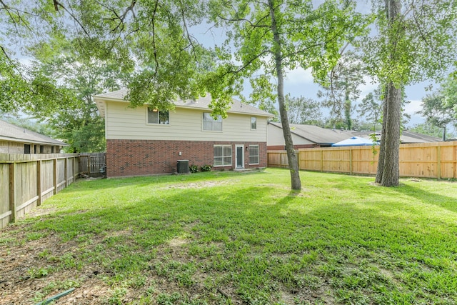 2318 Old Oak Ln, Kingwood, TX 77339 - rear view of house featuring brick siding and central air condition unit
