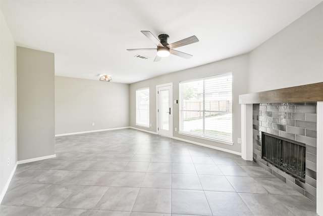 2318 Old Oak Ln, Kingwood, TX 77339 - unfurnished living room with a tiled fireplace, ceiling fan, and baseboards