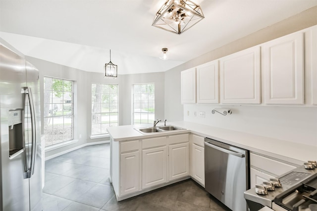2318 Old Oak Ln, Kingwood, TX 77339 - kitchen featuring stainless steel appliances, a sink, a peninsula, plenty of natural light, and vaulted ceiling