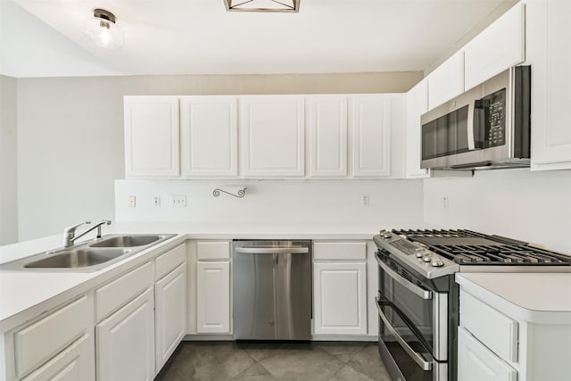 2318 Old Oak Ln, Kingwood, TX 77339 - kitchen featuring appliances with stainless steel finishes, a sink, white cabinetry, a peninsula, and light countertops