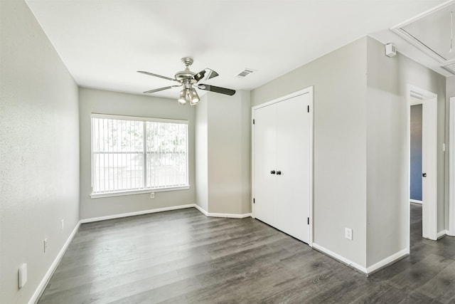 2318 Old Oak Ln, Kingwood, TX 77339 - unfurnished bedroom with attic access, dark wood finished floors, baseboards, and a ceiling fan
