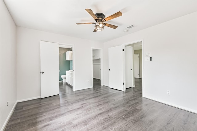 2318 Old Oak Ln, Kingwood, TX 77339 - unfurnished bedroom featuring wood finished floors, baseboards, ensuite bathroom, a walk in closet, and a closet