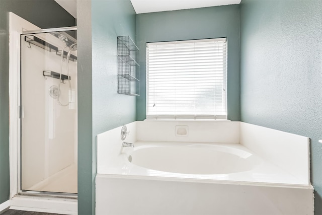 2318 Old Oak Ln, Kingwood, TX 77339 - full bathroom featuring a stall shower, a bath, and a textured wall