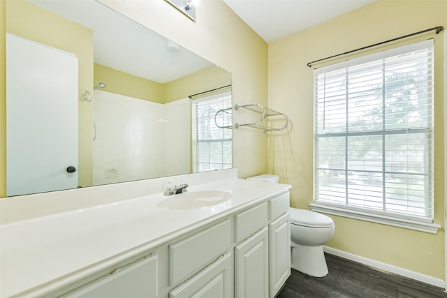 2318 Old Oak Ln, Kingwood, TX 77339 - full bath featuring toilet, wood finished floors, vanity, baseboards, and plenty of natural light
