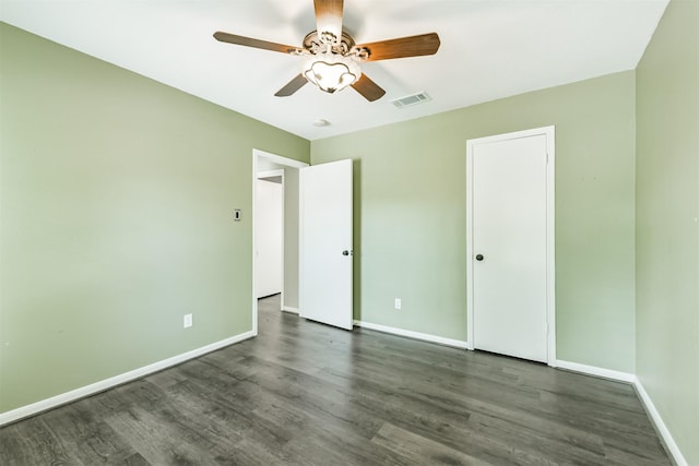 2318 Old Oak Ln, Kingwood, TX 77339 - unfurnished bedroom with dark wood-type flooring, baseboards, and a ceiling fan
