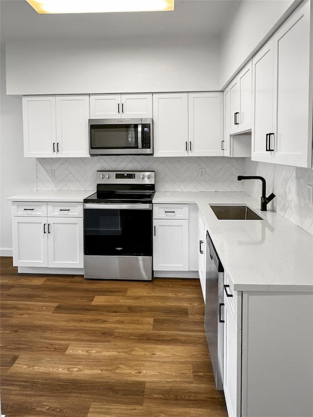11731 Lakeside Place Dr, Houston, TX 77077 - kitchen featuring stainless steel appliances, a sink, white cabinets, backsplash, and dark wood-type flooring