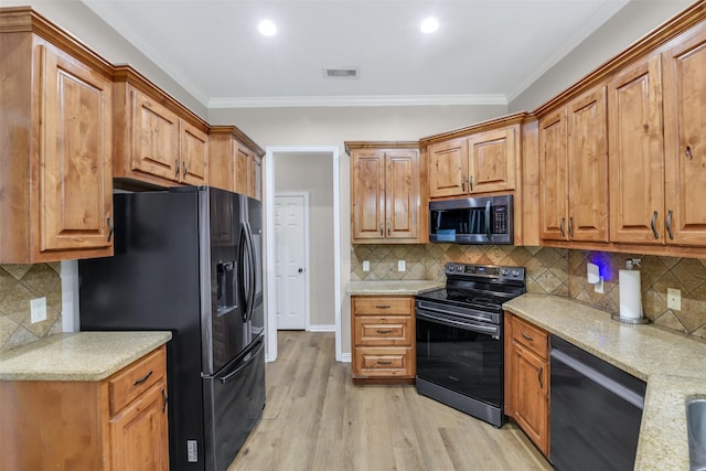 18024 Cindy Ln, Conroe, TX 77302 - kitchen featuring black appliances, tasteful backsplash, light wood-style floors, crown molding, and brown cabinetry